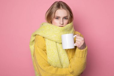 Sarı saçlı ve mavi gözlü güzel şehvetli kız sarı kazak ve eşarp giyiyor