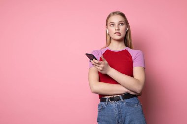 Elinde kulaklık ve telefon ile kırmızı t-shirt bir konfeti sevimli sarışın kız Fotoğrafı