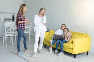 Gündelik kıyafetler giyen iki anne evde çocukların huzurunda küfür ediyor.