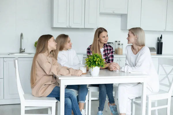 Lycklig lesbisk familj sitter tillsammans i köket hemma, alla i casual kläder — Stockfoto