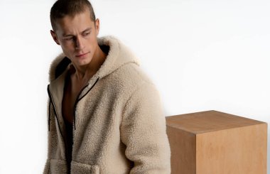 Kısa saç kesimi ile Ciddi yakışıklı adam, şık spor giyim giyiyor, sağa bakıyor, ceplerinde el ele tutuşarak, beyaz arka plan üzerinde izole