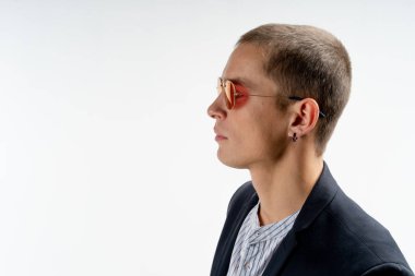 Siyah takım elbiseli genç ciddi bir adamın portresini kapatın ve beyaz arka plan üzerinde izole küpe, metniniz için copyspace