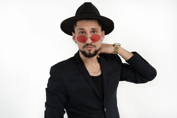 Hombre barbudo elegante guapo en traje negro y sombrero en gafas de sol redondas aisladas sobre fondo blanco, copyspace para su texto — Foto de Stock