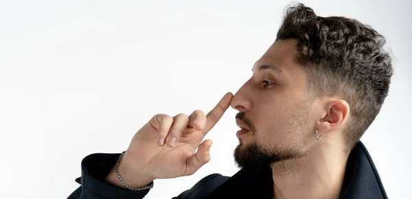 Vista lateral de cerca retrato de joven barbudo que tocándose la nariz con el dedo aislado sobre fondo blanco, espacio para su texto — Foto de Stock