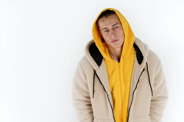 Retrato de mitad de longitud de un joven triste hombre con capucha amarilla de pie sobre fondo blanco, espacio de copia para su texto — Foto de Stock