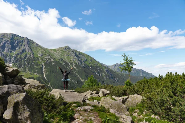 산 꼭대기 근처에 서있는 배낭을 가진 소녀 등산객, 손을 들고 활동적인 생활 컨셉 — 스톡 사진