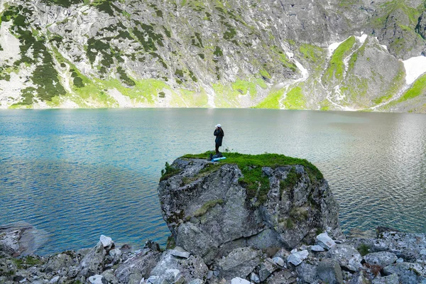 Güzel göl, aktif yaşam tarzı kavramı yakınında büyük kaya dağ üzerinde duran kız gezgin