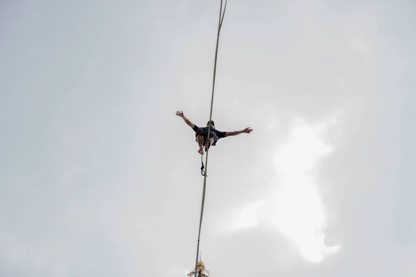 Foto von unten, tapferer Seiltänzer mit ausgebreiteten Armen mitten auf dem Weg — Stockfoto