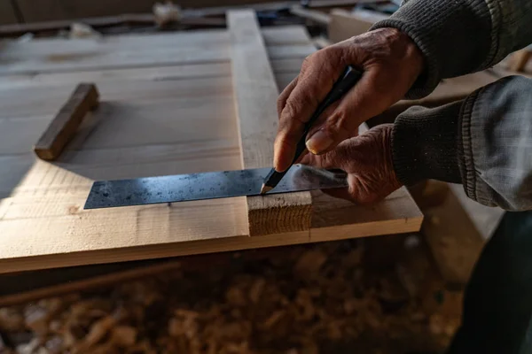 Foto da vicino di vecchie mani del maestro falegname che regge righello e matita, fa misurazioni — Foto Stock