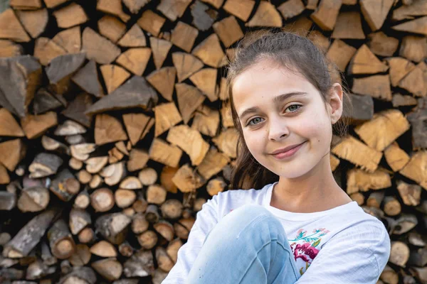 Gros plan portrait de belle fille brune mignonne avec une peau saine qui sourit et en regardant la caméra isolée sur fond de bois de chauffage — Photo