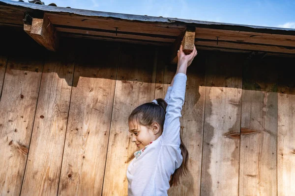 Vista lateral de la foto de la niña morena que sostienen tablón de madera extendido — Foto de Stock