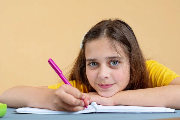 Chica adolescente estudiando sola leyendo libro de texto sentado en el escritorio de casa. Adolescente inteligente adolescente escuela estudiante a distancia aprendizaje con libro, tomando notas —  Fotos de Stock