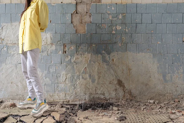 Menina não reconhecida em uma camisa amarela no edifício destruído da antiga fábrica. Consequências do Apocalipse, epidemia — Fotografia de Stock