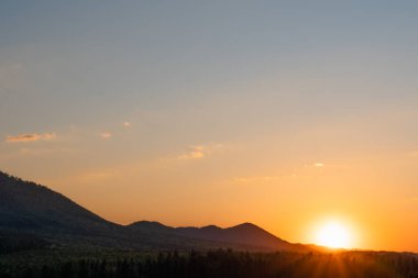 Arkasında günbatımı olan bir sıradağdan güzel bir manzara.