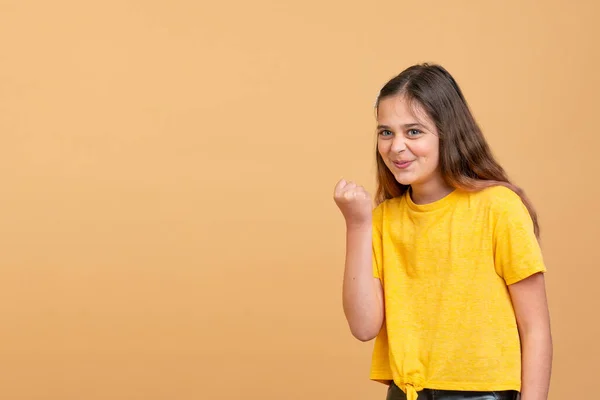 Enojado adolescente chica en amarillo camiseta mostrando puño en cámara —  Fotos de Stock