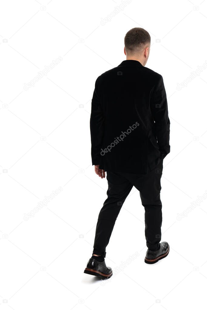 Back view of a young business man walking, isolated on white background