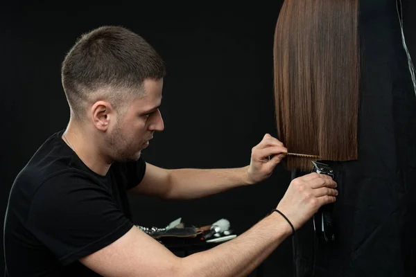 Joven peluquero confiado recortando el pelo a su cliente —  Fotos de Stock