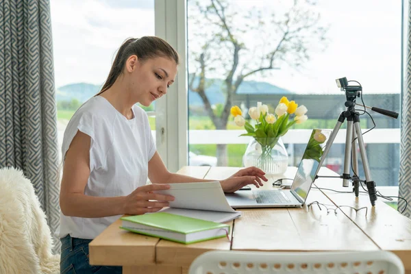 Focalisé jeune femme indépendante assise sur la table à la maison avec ordinateur portable, travaillant à distance en ligne à partir de la maison Images De Stock Libres De Droits