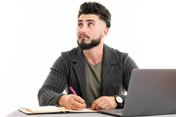 The face of plenary leadership.Thoughtful businessman in formalwear holding pen in hand while sitting at his working place — Stock Photo, Image