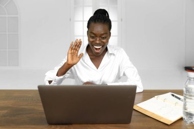 Şirket iletişimi. Modern ofiste web kamerası laptopunda konuşan siyahi bir iş kadını. Boş alan