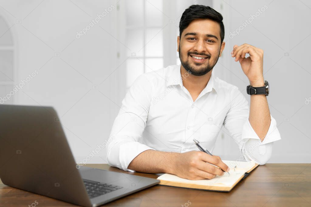 Asian student studying, learning language, online education concept. Portrait of handsome Indian businessman using laptop computer, working in office