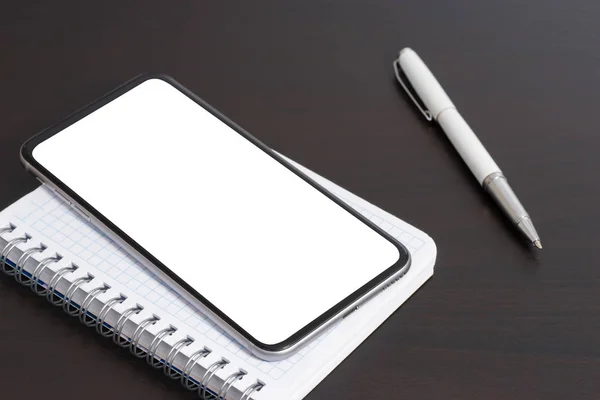 Smartphone Ένα Σημειωματάριο Και Στυλό Στο Σκοτεινό Τραπέζι — Φωτογραφία Αρχείου