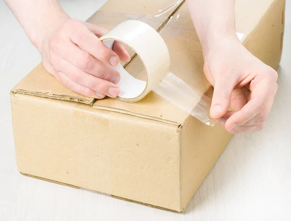 Hands with roll adhesive tape — Stock Photo, Image