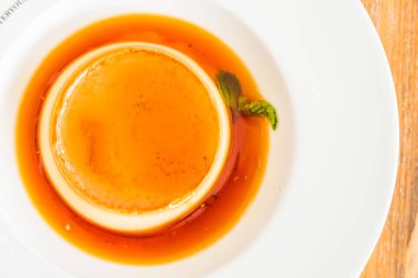 Karamel kremalı puding beyaz plaka - seçici odak noktası