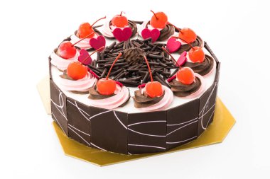 Üzerinde kiraz olan çikolatalı pasta beyaz arka planda izole edilmiş.