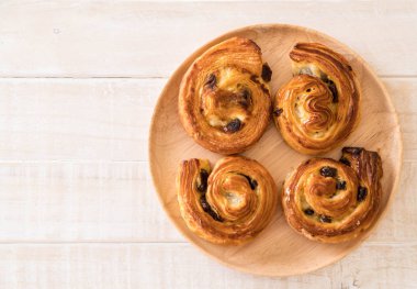 tarçınlı üzümlü rulo ahşap plaka üzerinde