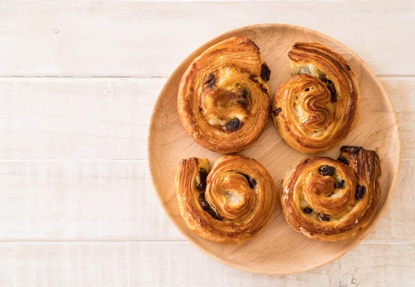 tarçınlı üzümlü rulo ahşap plaka üzerinde