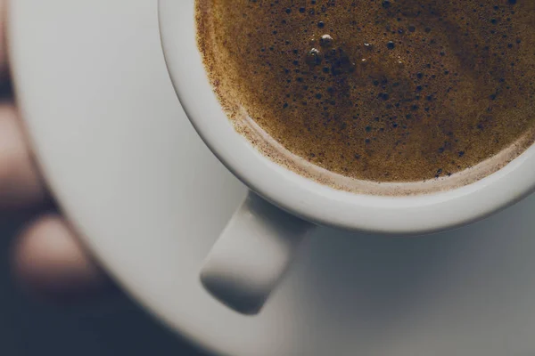 Küçük seramik Kupası'nda lezzetli köpük lezzetli kahve espresso closeup. Erkek holding sıcak sıcak içecek eller. 