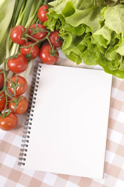 野菜サラダ空白のレシピ本やチェックのテーブル クロスの上の買い物リストの選択 — ストック写真