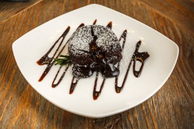 Beyaz bir tepside pudra şekeri ile çikolatalı kek.