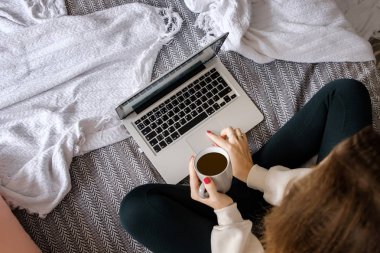 Kız dizüstü kitap çalışır ve koyu bir kahve içer.