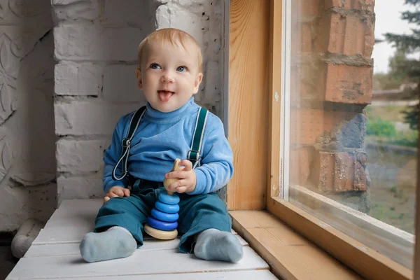 Красива Щаслива Блакитноока Дитина Сидить Підвіконні Іграшкою Показує Язик Камері — стокове фото