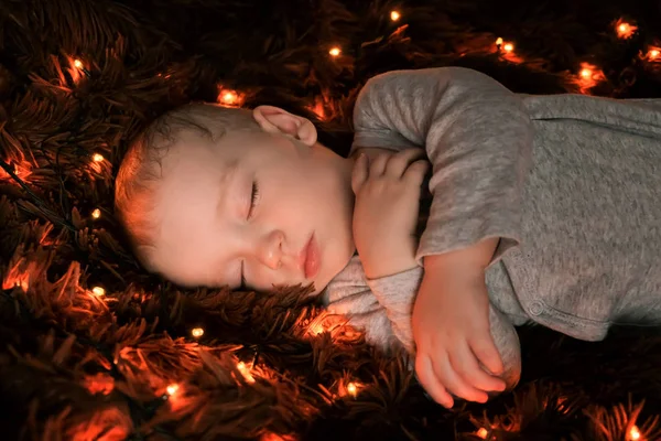 ふわふわの茶色の毛布の上で眠る赤ちゃん ライトは彼のまわりに広がっています — ストック写真