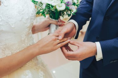 Damat geline nikah yüzüğü takıyor.