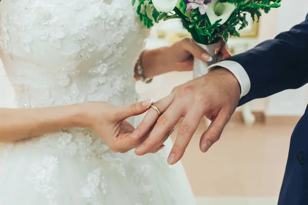 The bride wears a ring to the groom at the wedding ceremony.