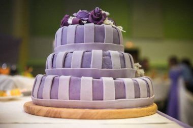 Masanın üzerine çiçek katmanlı düğün pastası standları.