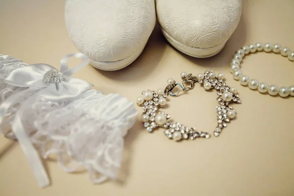 Wedding accessory bride. Stylish shoes, earrings, garter standing on white background. flat lay. top view. Marriage concept.