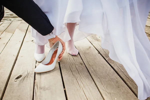 The groom helps the bride to get stuck between the boards Shoe.