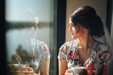 Güzel bir genç gelin sabah kahvesini bir hote içinde keyif alıyor