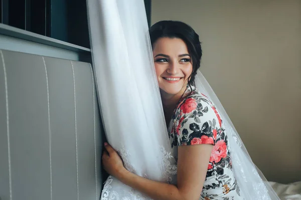 Krásná dívka obdivuje její svatební šaty. Ráno si nevěsta — Stock fotografie