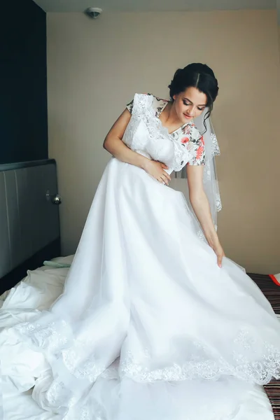Krásná dívka obdivuje její svatební šaty. Ráno si nevěsta — Stock fotografie