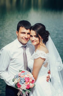 Mavi açık Gölü yakınındaki bir güzel yeni evli çift ayakta. On