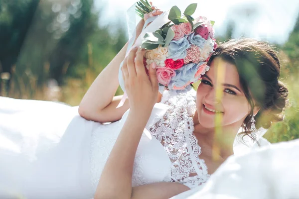 Retrato de uma bela noiva feliz contra um prado verde e f — Fotografia de Stock