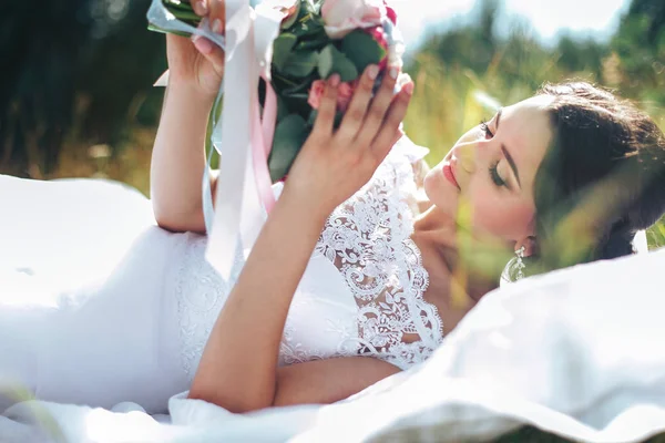 Retrato de uma bela noiva feliz contra um prado verde e f — Fotografia de Stock