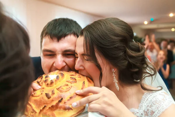 Das Brautpaar beißt in die Hochzeitstorte. Hochzeitstradition — Stockfoto