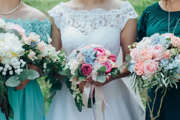 Bouquets de flores nas mãos da noiva e seus amigos — Fotografia de Stock